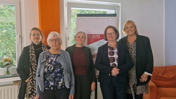 Das Bild zeigt 5 Frauen vor einem Fenster mit einem Aufsteller im Hintergrund.
