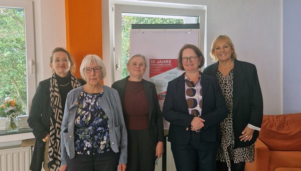 Das Bild zeigt 5 Frauen vor einem Fenster mit einem Aufsteller im Hintergrund.